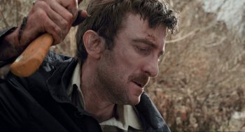 Movie still from “District 9” (2009), directed by Neill Blomkamp – A person cutting his own hair; Close Up shot, Over the shoulder angle