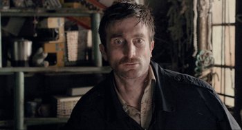 Movie still from “District 9” (2009), directed by Neill Blomkamp – A person wearing a shirt and jacket; Close Up shot, Over the shoulder angle