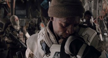 Movie still from “District 9” (2009), directed by Neill Blomkamp – A man with a hat on looking at a camera; Close Up shot, Low angle