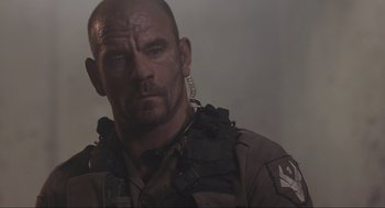 Movie still from “District 9” (2009), directed by Neill Blomkamp – A person wearing a military uniform; Close Up shot, Low angle