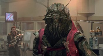 Movie still from “District 9” (2009), directed by Neill Blomkamp – An image of an alien character in a movie setting; Medium shot, Low angle