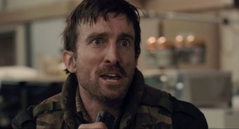 Movie still from “District 9” (2009), directed by Neill Blomkamp – A person holding a microphone; Close Up shot, Over the shoulder angle