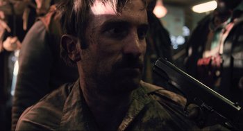 Movie still from “District 9” (2009), directed by Neill Blomkamp – A person holding a knife; Close Up shot, Over the shoulder angle