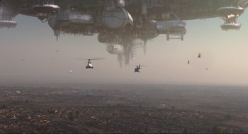 Movie still from “District 9” (2009), directed by Neill Blomkamp – A group of people in a field with a helicopter flying above; Extreme Wide shot, Low angle