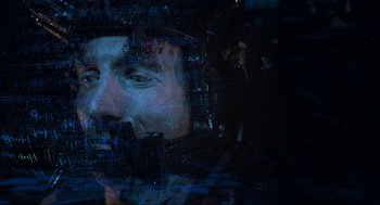 Movie still from “District 9” (2009), directed by Neill Blomkamp – A man in a helmet is reflected in a window; Close Up shot, Overhead angle