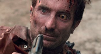 Movie still from “District 9” (2009), directed by Neill Blomkamp – A person holding a gun; Extreme Close Up shot, Over the shoulder angle