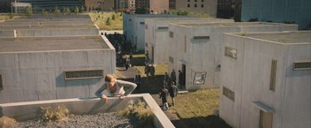 Movie still from “Divergent” (2014), directed by Neil Burger – A group of people standing around a building; Extreme Wide shot, High angle