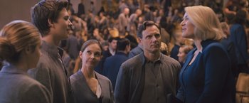 Movie still from “Divergent” (2014), directed by Neil Burger – A man and a woman standing next to each other in a crowd; Medium shot, Over the shoulder angle