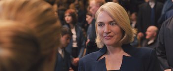 Movie still from “Divergent” (2014), directed by Neil Burger – A woman in a suit standing in front of a group of people; Close Up shot, Over the shoulder angle