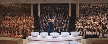 Movie still from “Divergent” (2014), directed by Neil Burger – A woman standing in front of a group of people; Extreme Wide shot, High angle
