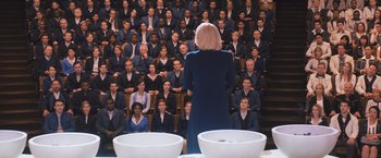 Movie still from “Divergent” (2014), directed by Neil Burger – A woman standing in front of a group of people; Wide shot, High angle