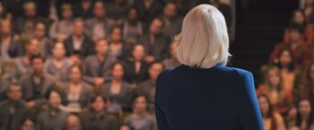 Movie still from “Divergent” (2014), directed by Neil Burger – A woman standing in front of a group of people; Medium shot, Over the shoulder angle