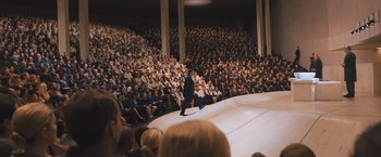 Movie still from “Divergent” (2014), directed by Neil Burger – An audience is watching a man on a stage in front of an audience; Extreme Wide shot, High angle