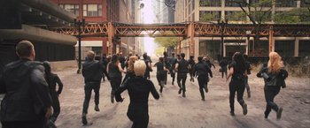 Movie still from “Divergent” (2014), directed by Neil Burger – A group of people running down a street; Wide shot, High angle