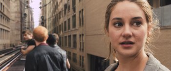Movie still from “Divergent” (2014), directed by Neil Burger – A woman's face in front of a building; Close Up shot, Over the shoulder angle