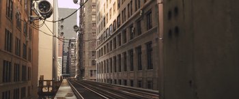 Movie still from “Divergent” (2014), directed by Neil Burger – A train track in front of a tall building; Extreme Wide shot, High angle