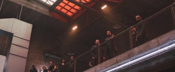 Movie still from “Divergent” (2014), directed by Neil Burger – A group of people standing on top of a railing in a building; Wide shot, Low angle