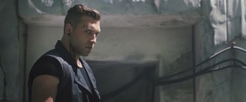 Movie still from “Divergent” (2014), directed by Neil Burger – A man with a shaved head looking to his left; Close Up shot, Low angle