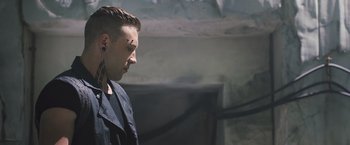 Movie still from “Divergent” (2014), directed by Neil Burger – A man with a shaved head and a tattoo on his forehead; Close Up shot, Low angle