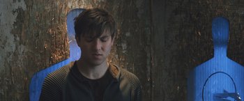 Movie still from “Divergent” (2014), directed by Neil Burger – A young man with his eyes closed looking down at the ground; Close Up shot, Low angle