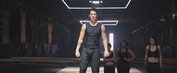 Movie still from “Divergent” (2014), directed by Neil Burger – A man in a black tank top and black pants; Medium shot, Low angle