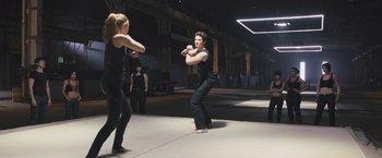 Movie still from “Divergent” (2014), directed by Neil Burger – Two women are practicing boxing in an indoor setting; Wide shot, Over the shoulder angle