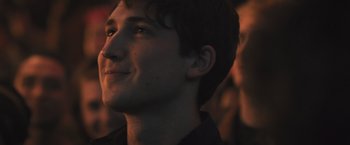 Movie still from “Divergent” (2014), directed by Neil Burger – A young man's face in the dark; Close Up shot, Over the shoulder angle
