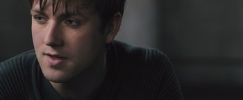 Movie still from “Divergent” (2014), directed by Neil Burger – A man's face in a dark room; Close Up shot, Over the shoulder angle
