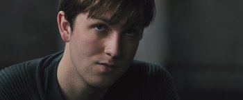 Movie still from “Divergent” (2014), directed by Neil Burger – A man's face in a dark room; Close Up shot, Low angle