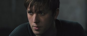 Movie still from “Divergent” (2014), directed by Neil Burger – A man's face in a dark room; Close Up shot, Over the shoulder angle