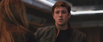 Movie still from “Divergent” (2014), directed by Neil Burger – A young man in a black shirt and a brown jacket; Close Up shot, Low angle