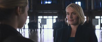 Movie still from “Divergent” (2014), directed by Neil Burger – A woman standing in front of a group of people; Close Up shot, Over the shoulder angle