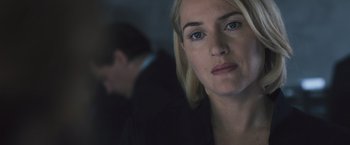 Movie still from “Divergent” (2014), directed by Neil Burger – A woman's face with a man in the background; Close Up shot, Over the shoulder angle