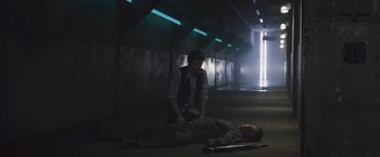 Movie still from “Divergent” (2014), directed by Neil Burger – A man is kneeling down next to a dead man; Wide shot, High angle