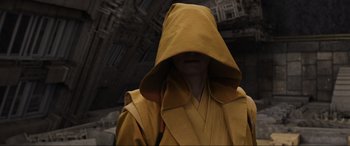 Movie still from “Doctor Strange” (2016), directed by Scott Derrickson – A person wearing a yellow robe and a yellow hood; Medium shot, Over the shoulder angle