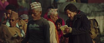 Movie still from “Doctor Strange” (2016), directed by Scott Derrickson – A group of people standing around looking at a piece of paper; Medium shot, Over the shoulder angle