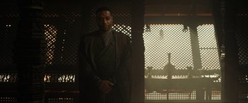 Movie still from “Doctor Strange” (2016), directed by Scott Derrickson – A man standing in front of a wooden wall; Medium shot, Low angle