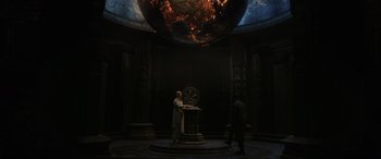 Movie still from “Doctor Strange” (2016), directed by Scott Derrickson – Two men standing in front of a globe in a room; Extreme Wide shot, High angle