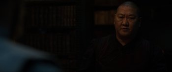 Movie still from “Doctor Strange” (2016), directed by Scott Derrickson – A man is sitting in front of a book shelf; Close Up shot, Over the shoulder angle