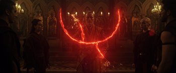 Movie still from “Doctor Strange” (2016), directed by Scott Derrickson – A man in a robe is holding a red light in a circle; Medium shot, Low angle