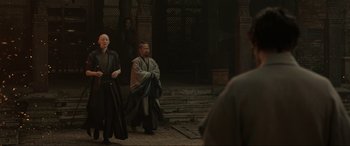 Movie still from “Doctor Strange” (2016), directed by Scott Derrickson – Two men dressed in traditional chinese garb are sitting on the steps; Wide shot, Over the shoulder angle