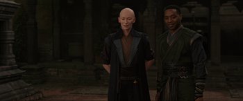 Movie still from “Doctor Strange” (2016), directed by Scott Derrickson – A man with a bald head standing next to another man; Medium shot, Over the shoulder angle