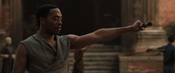 Movie still from “Doctor Strange” (2016), directed by Scott Derrickson – A black man is standing in front of some stairs; Medium shot, Low angle