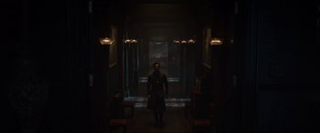 Movie still from “Doctor Strange” (2016), directed by Scott Derrickson – A man is walking through a dark hallway; Wide shot, Low angle