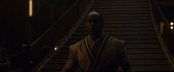 Movie still from “Doctor Strange” (2016), directed by Scott Derrickson – A man standing in front of some stairs; Medium shot, Low angle