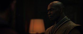 Movie still from “Doctor Strange” (2016), directed by Scott Derrickson – A bald man is standing in front of a lamp; Close Up shot, Over the shoulder angle