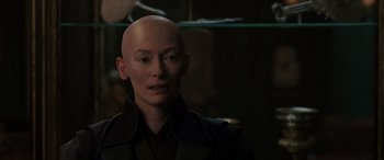 Movie still from “Doctor Strange” (2016), directed by Scott Derrickson – A woman with a bald head is looking at the camera; Close Up shot, High angle