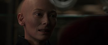 Movie still from “Doctor Strange” (2016), directed by Scott Derrickson – A person with a shaved head; Close Up shot, Over the shoulder angle