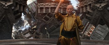 Movie still from “Doctor Strange” (2016), directed by Scott Derrickson – A woman in a yellow and black outfit standing in front of a building; Medium shot, Low angle