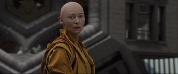 Movie still from “Doctor Strange” (2016), directed by Scott Derrickson – A woman with a bald head is posing for a picture; Close Up shot, High angle